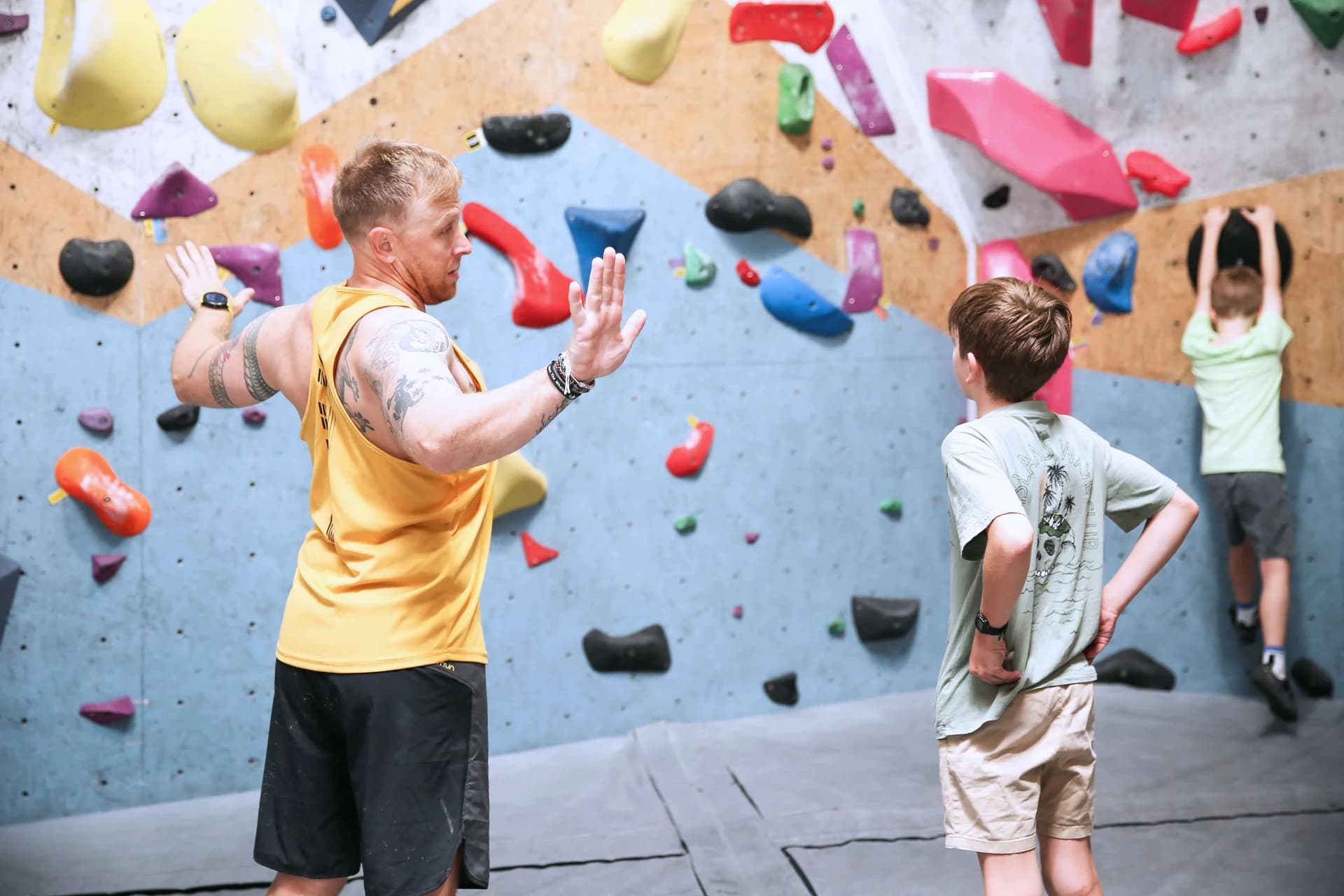 A coach explaining climbing technique to a participant at Wall Walkers.